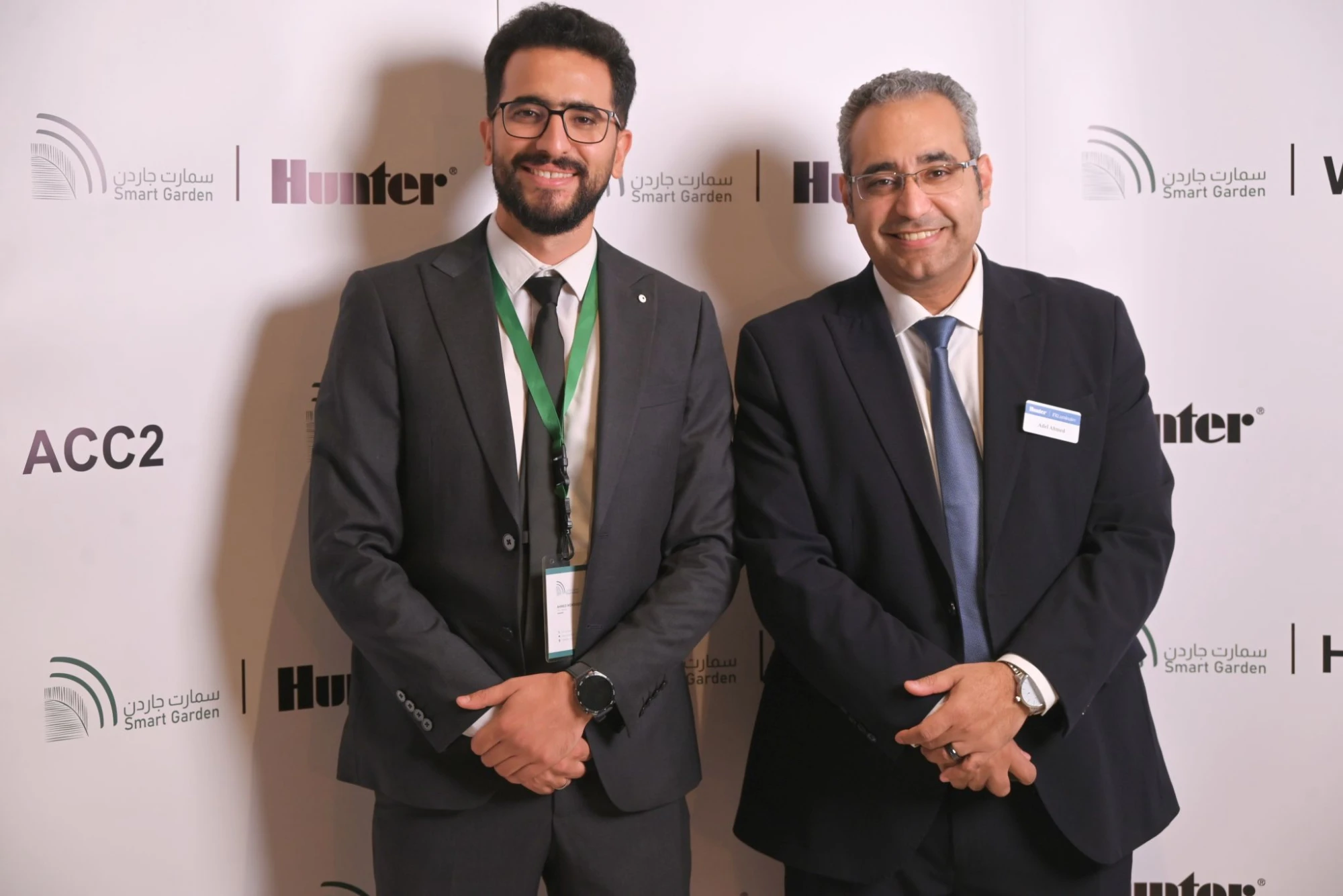 حاضران أمام جدار الندوة الذي يحمل شعاري الحديقة الذكية وHunter.