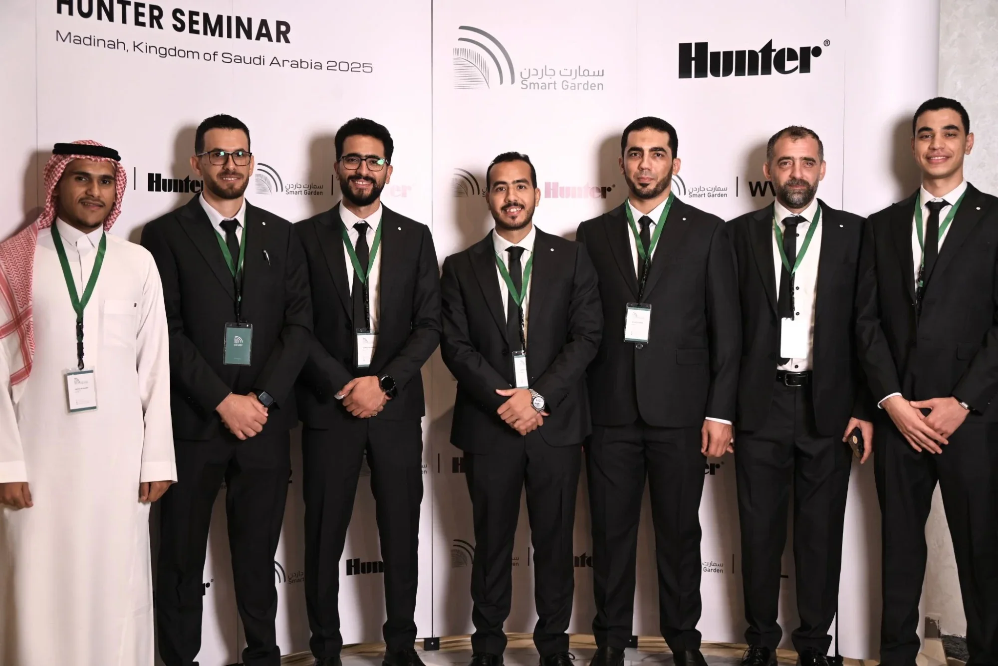 مجموعة أكبر من فريق الحديقة الذكية أمام جدار الندوة، وعليه عنوان ندوة Hunter بالمدينة المنورة وشعارا الحديقة الذكية وHunter.