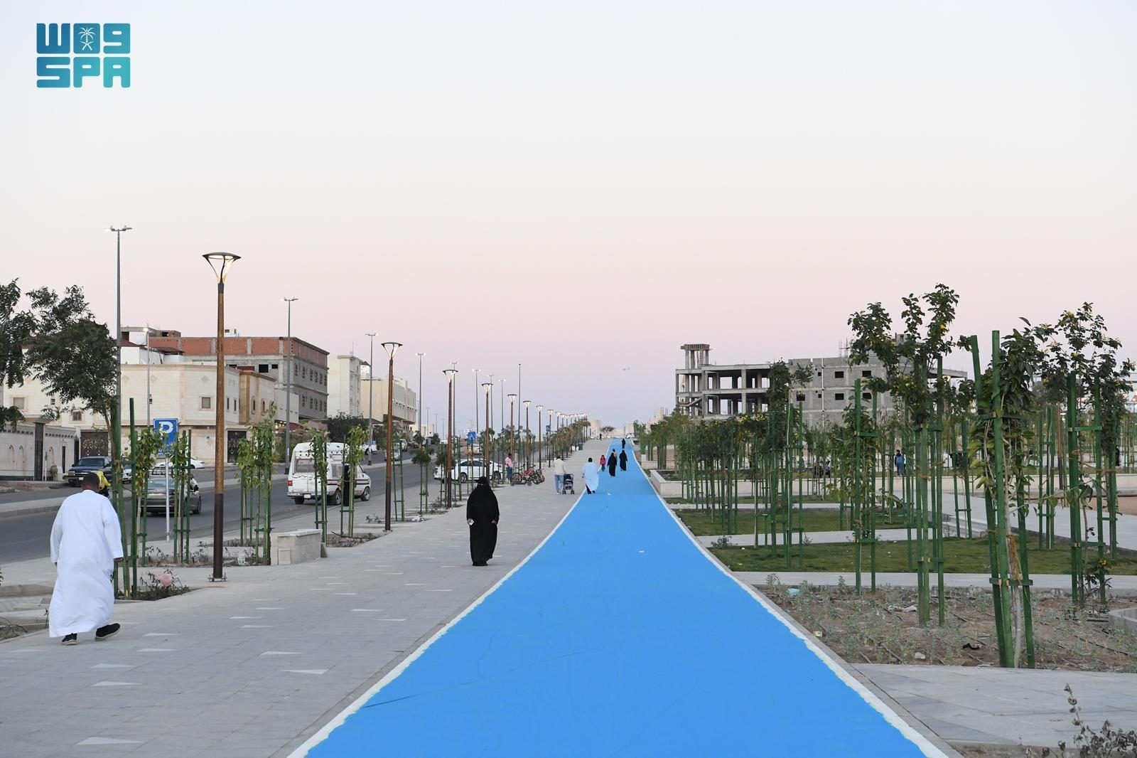 المسار الأزرق نهاراً وعلى جانبيه مشاة وأشجار
